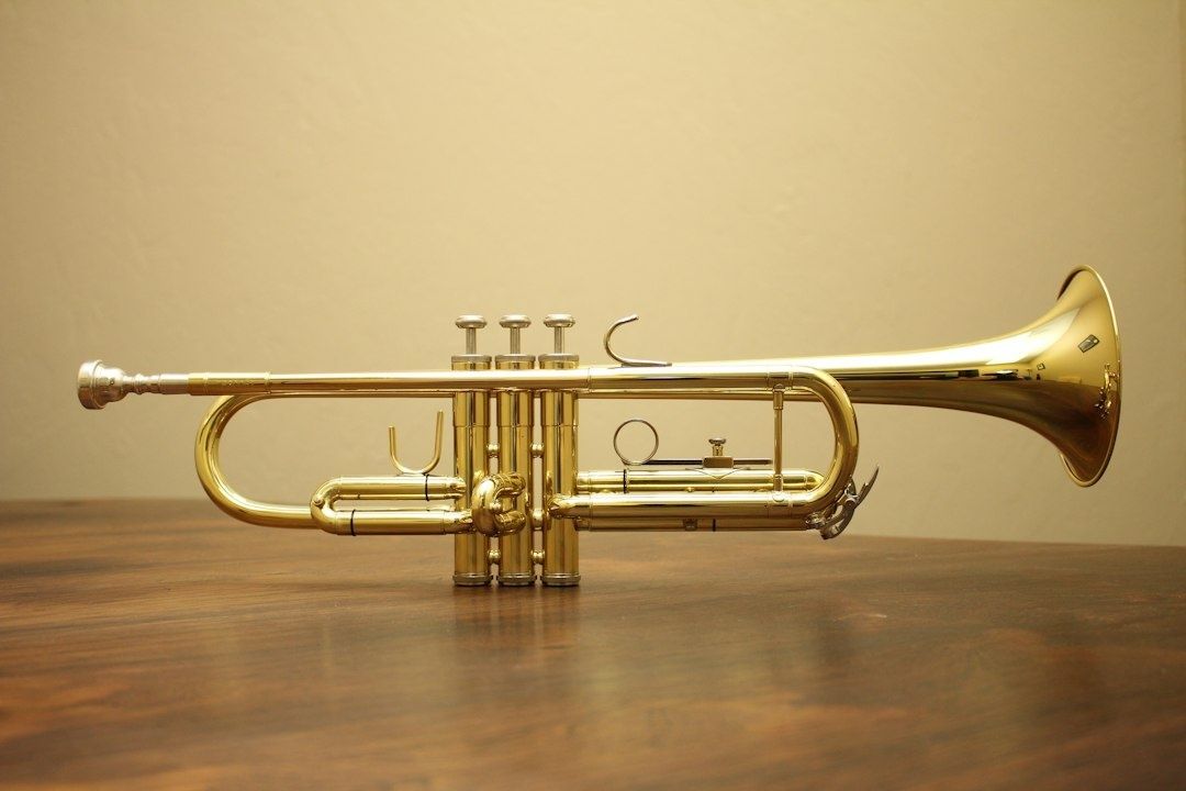 Polished brass trumpet resting on a wooden table