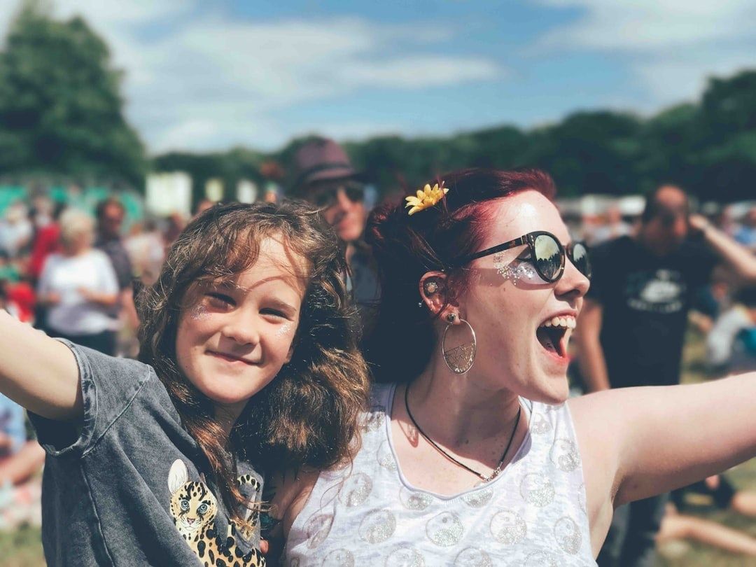 Smiling woman and child enjoying a lively outdoor community festival